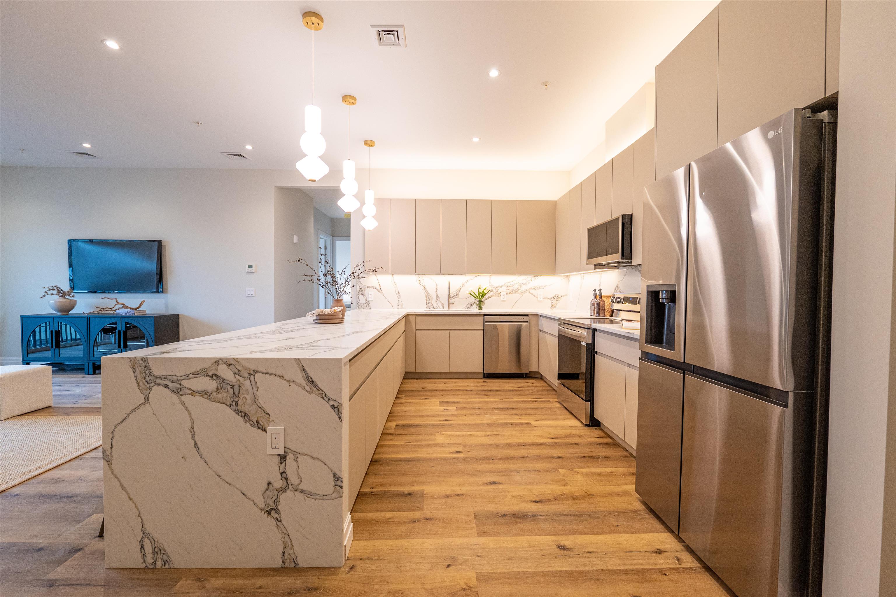 1722 Springfield Avenue, Unit 302 Maplewood, NJ 07040 - Photo 4 of 31 a large kitchen with kitchen island a counter top space a refrigerator a stove a sink dishwasher and a oven with wooden floor