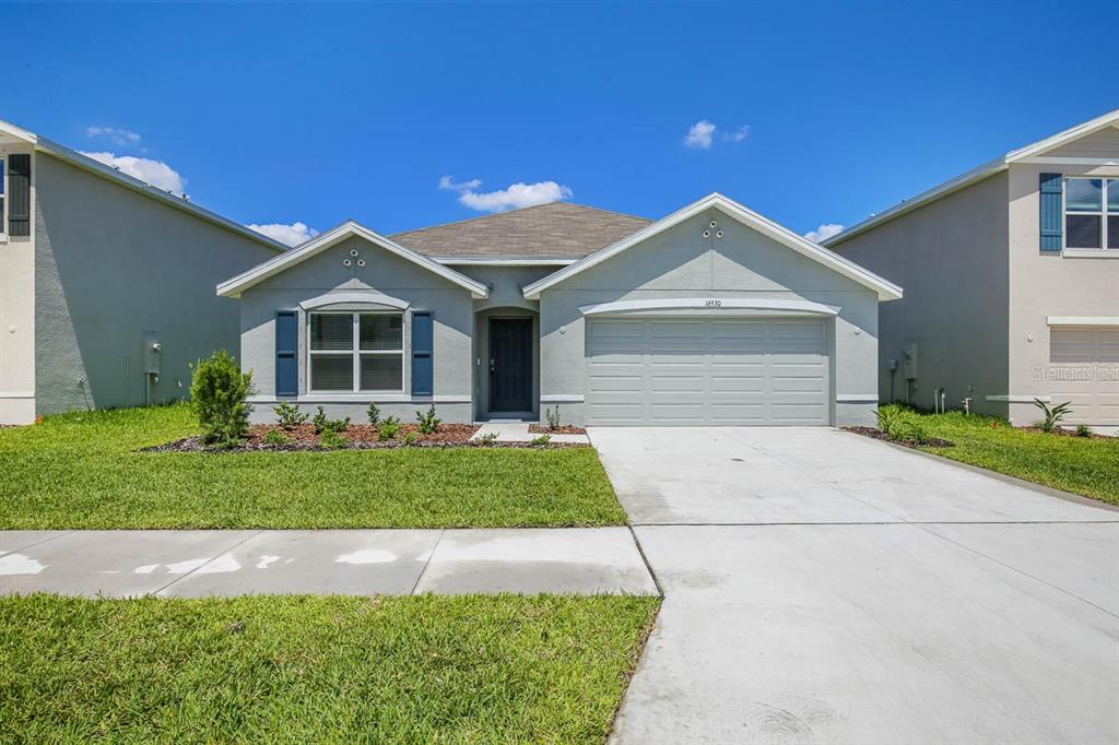 16530 Windmill Forge Pass Wimauma, FL 33598 - Photo 1 of 33 a front view of a house with a yard and garage