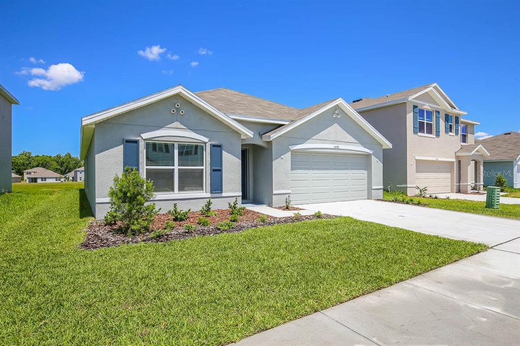 16530 Windmill Forge Pass Wimauma, FL 33598 - Photo 2 of 33 a front view of a house with a garden and plants