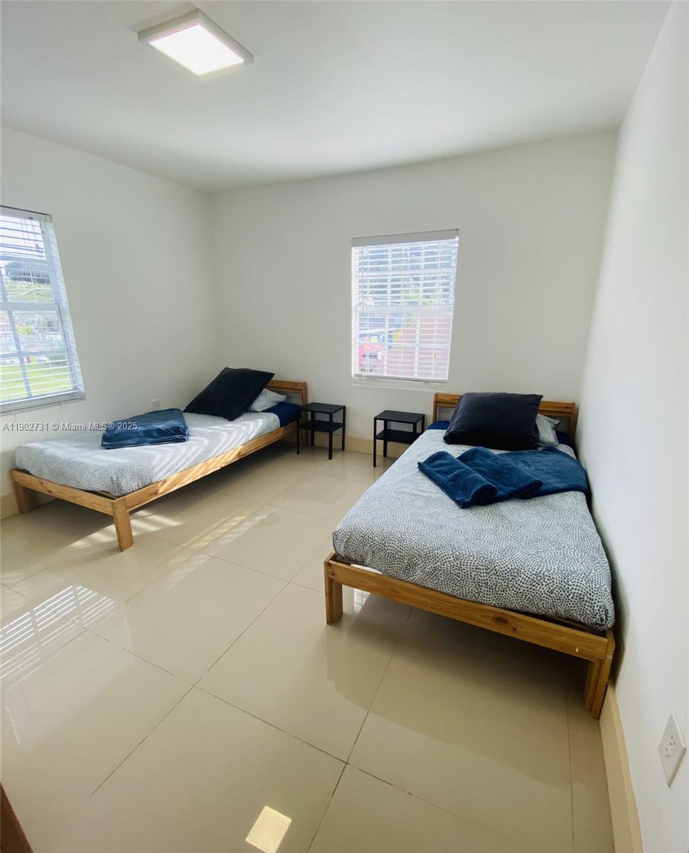 227 Northwest 34th Street, Unit 3 Miami, FL 33127 - Photo 3 of 6 a bedroom with a bed and a window