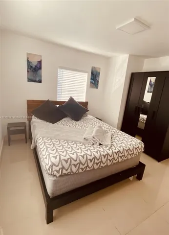 a bedroom with a bed lamp and a dresser