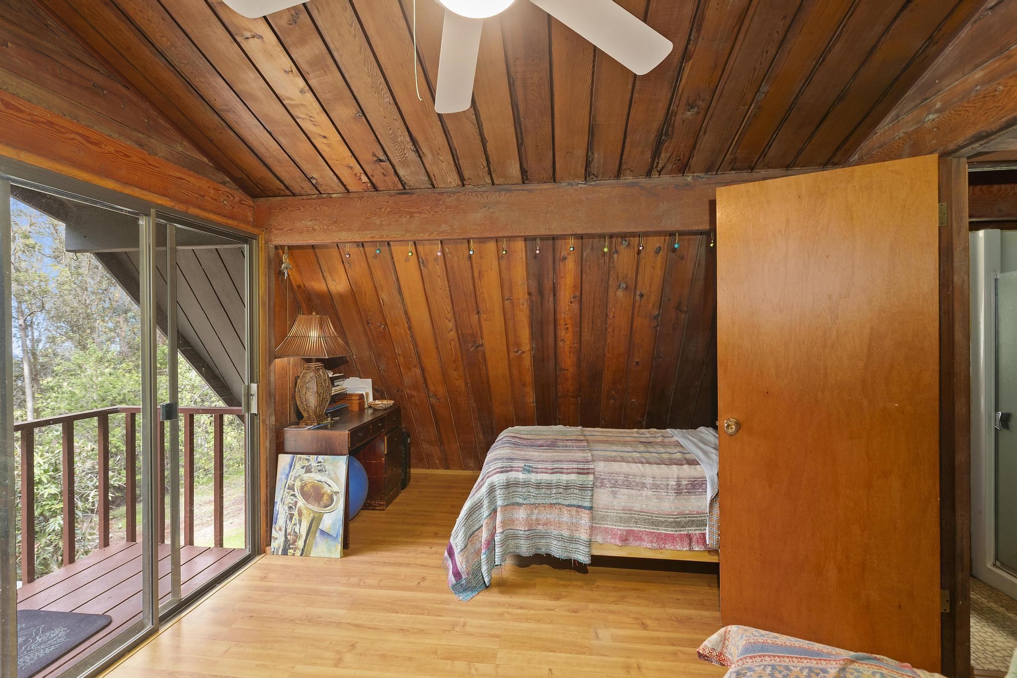 2450 Piiholo Road Makawao, HI 96768 - Photo 29 of 39 a bedroom with a bed and wooden floor