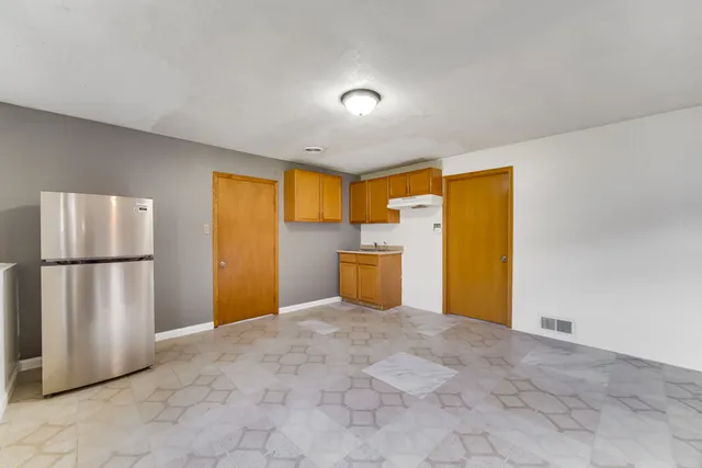 a view of a kitchen with refrigerator and a sink