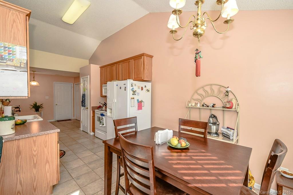 4004 Lake Park Road Indian Trail, NC 28079 - Photo 5 of 19 a view of a dining room with furniture a chandelier and wooden floor