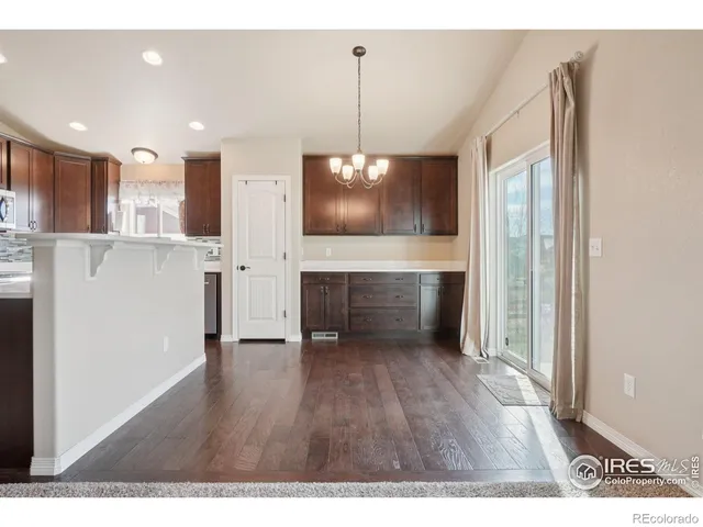 a view of an empty room with wooden floor fireplace and a window