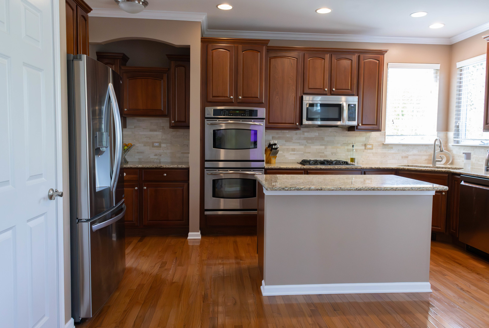 421 Post Oak Circle West Chicago, IL 60185 - Photo 10 of 22 a kitchen with kitchen island granite countertop a stove top oven a sink and dishwasher with wooden floor
