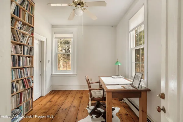 a view of a workspace with furniture and a bookshelf