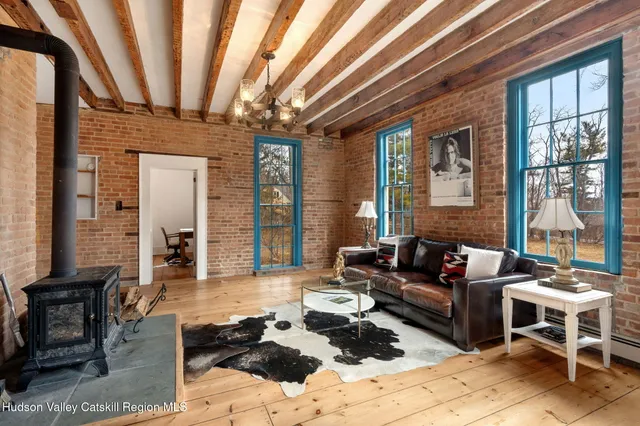 a living room with furniture wooden floor and large windows