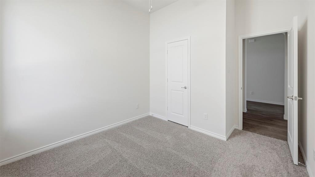 4163 Waldron Trail Forney, TX 75126 - Photo 23 of 30 Neutral-toned carpeting extending through the space, contrasted with white baseboards and walls