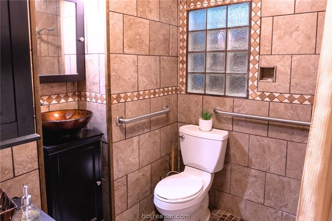 749 South Cass Street Centerville, TX 75833 - Photo 20 of 30 a bathroom with a toilet a sink and a window