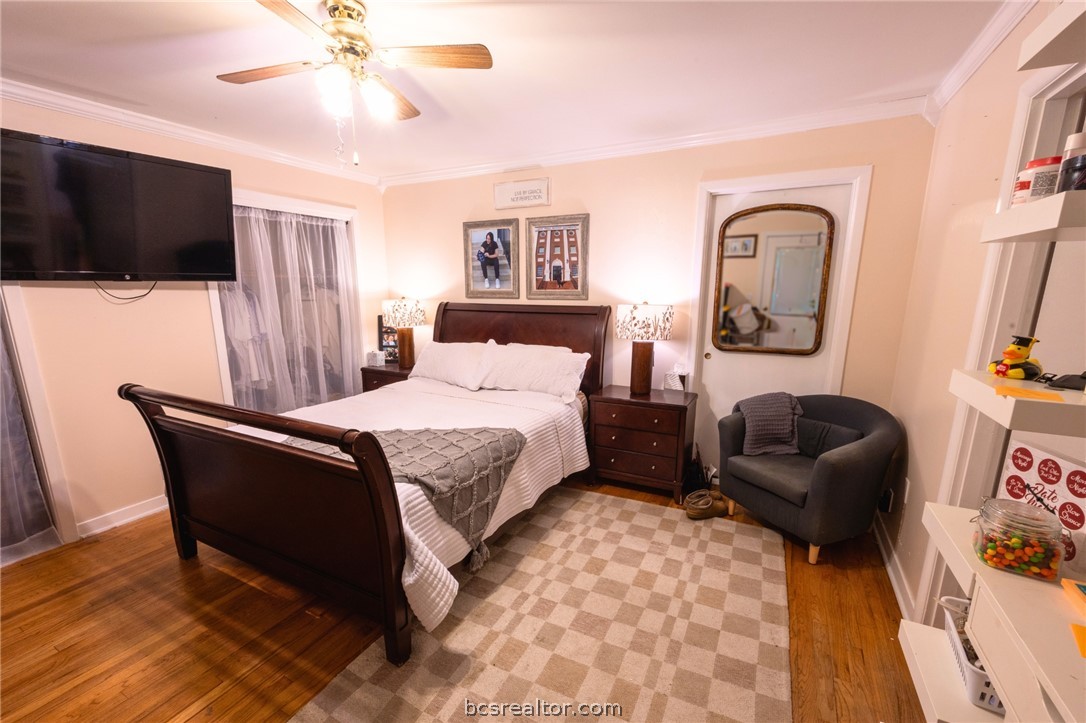 749 South Cass Street Centerville, TX 75833 - Photo 21 of 30 a bedroom with a bed a flat screen tv and paintings on the wall