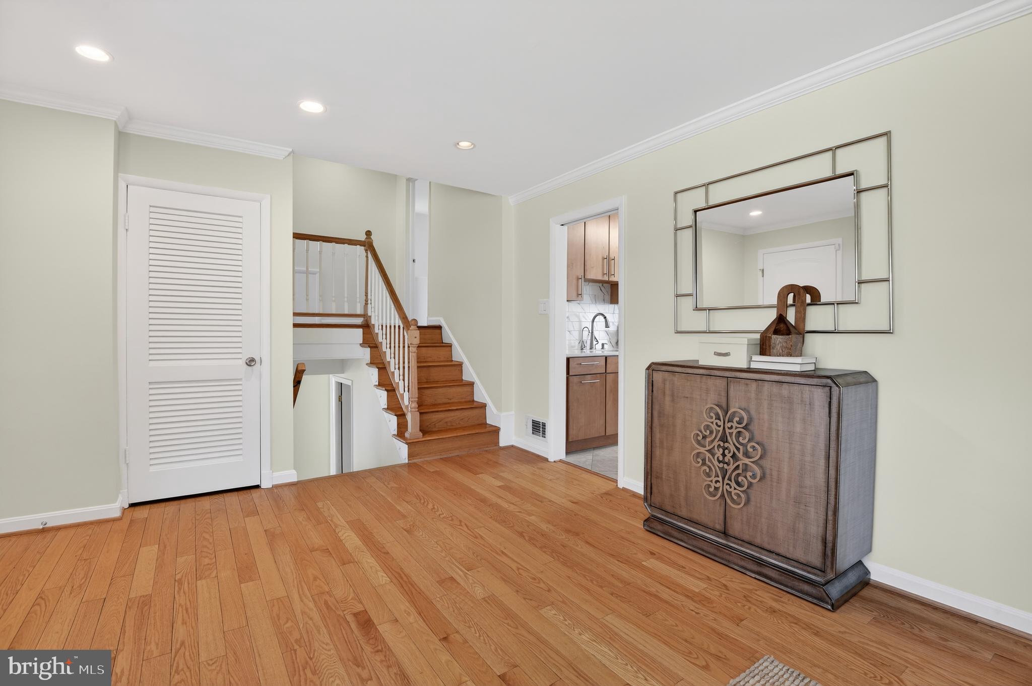 11004 Oakwood Street Silver Spring, MD 20901 - Photo 16 of 35 a hallway with a view of kitchen with wooden floor and electronic appliances