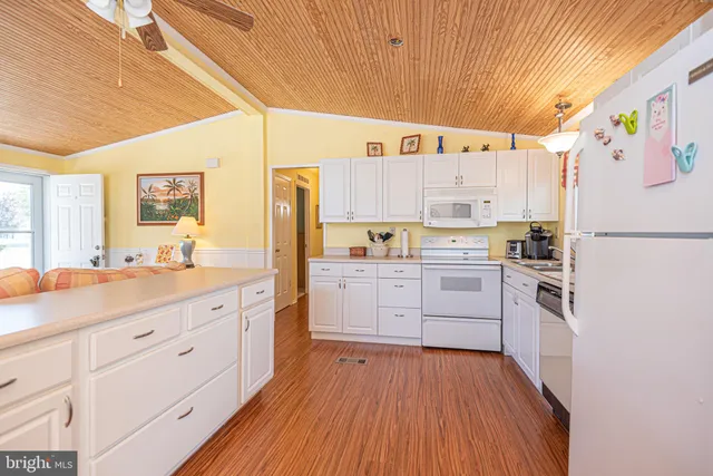 a kitchen with white cabinets and white appliances