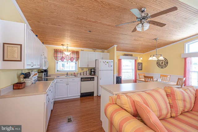 a living room with stainless steel appliances kitchen island granite countertop furniture and a large window