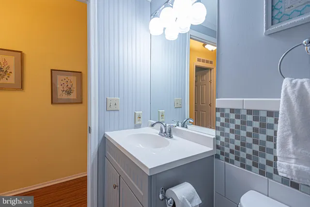 a bathroom with a sink a light fixture and a mirror