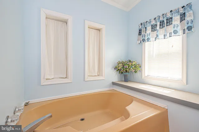 a bath tub sitting in a bathroom next to a window