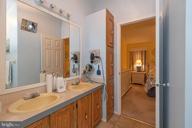 a en suite bathroom with a granite countertop sink and a mirror