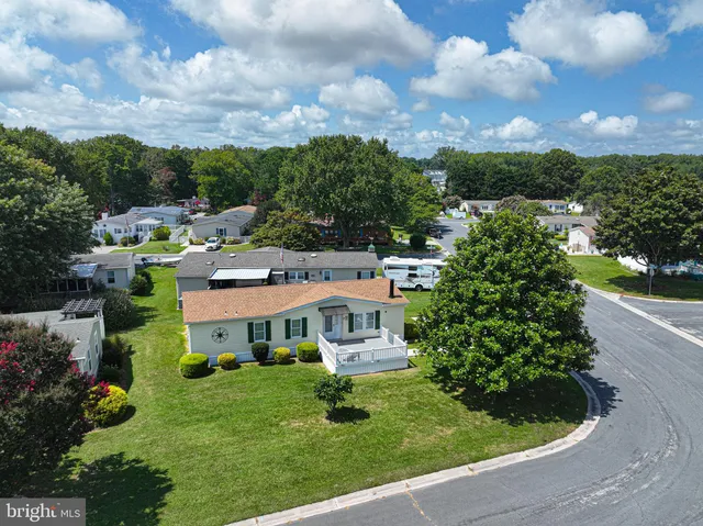 a view of a house with a big yard plants and large trees