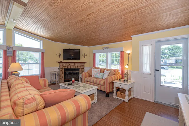 a living room with fireplace furniture and a large window