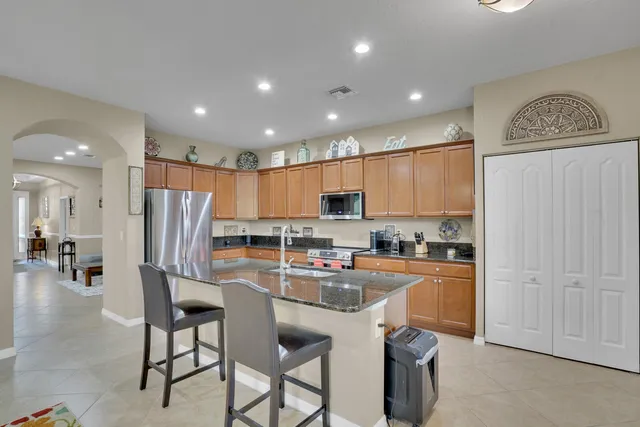 a kitchen with stainless steel appliances granite countertop a refrigerator and a stove top oven