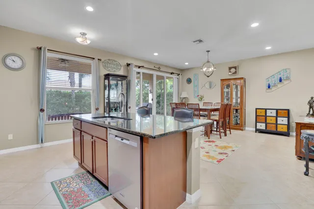 a kitchen with stainless steel appliances granite countertop a stove and a large window