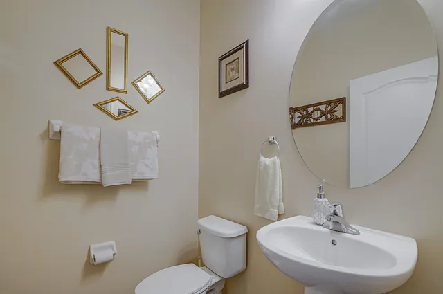 a bathroom with a toilet a sink and mirror