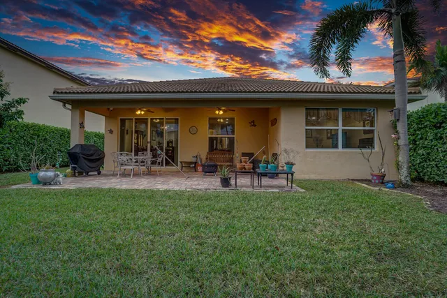 a view of a patio with table and chairs potted plants and large tree