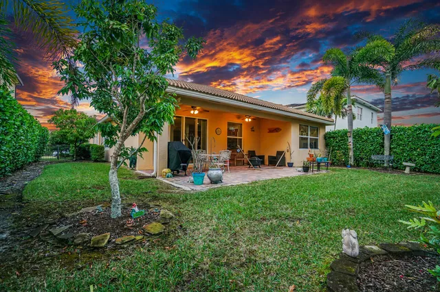 a view of a patio with table and chairs potted plants and palm tree