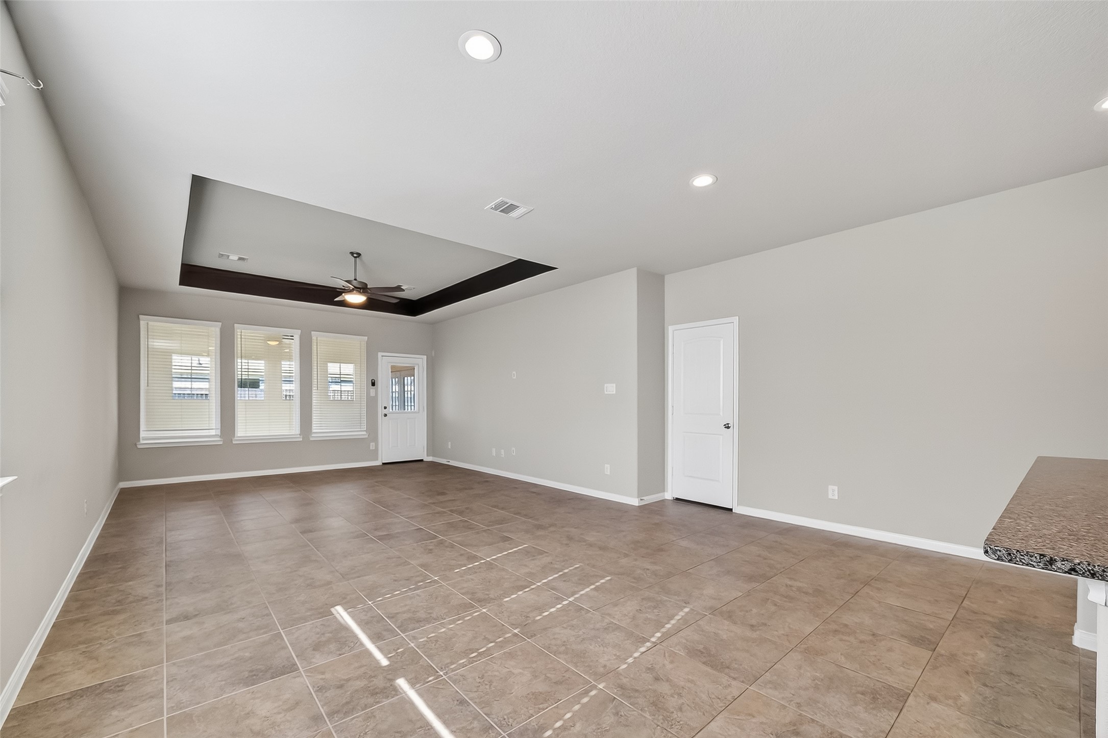 5 Lucas Chase Court Manvel, TX 77578 - Photo 12 of 50 This open-concept living area connects seamlessly to the kitchen and dining space — perfect for hosting, everyday hangouts, or keeping an eye on the kids while you cook. The tray ceiling and ceiling fan add a stylish, functional touch.