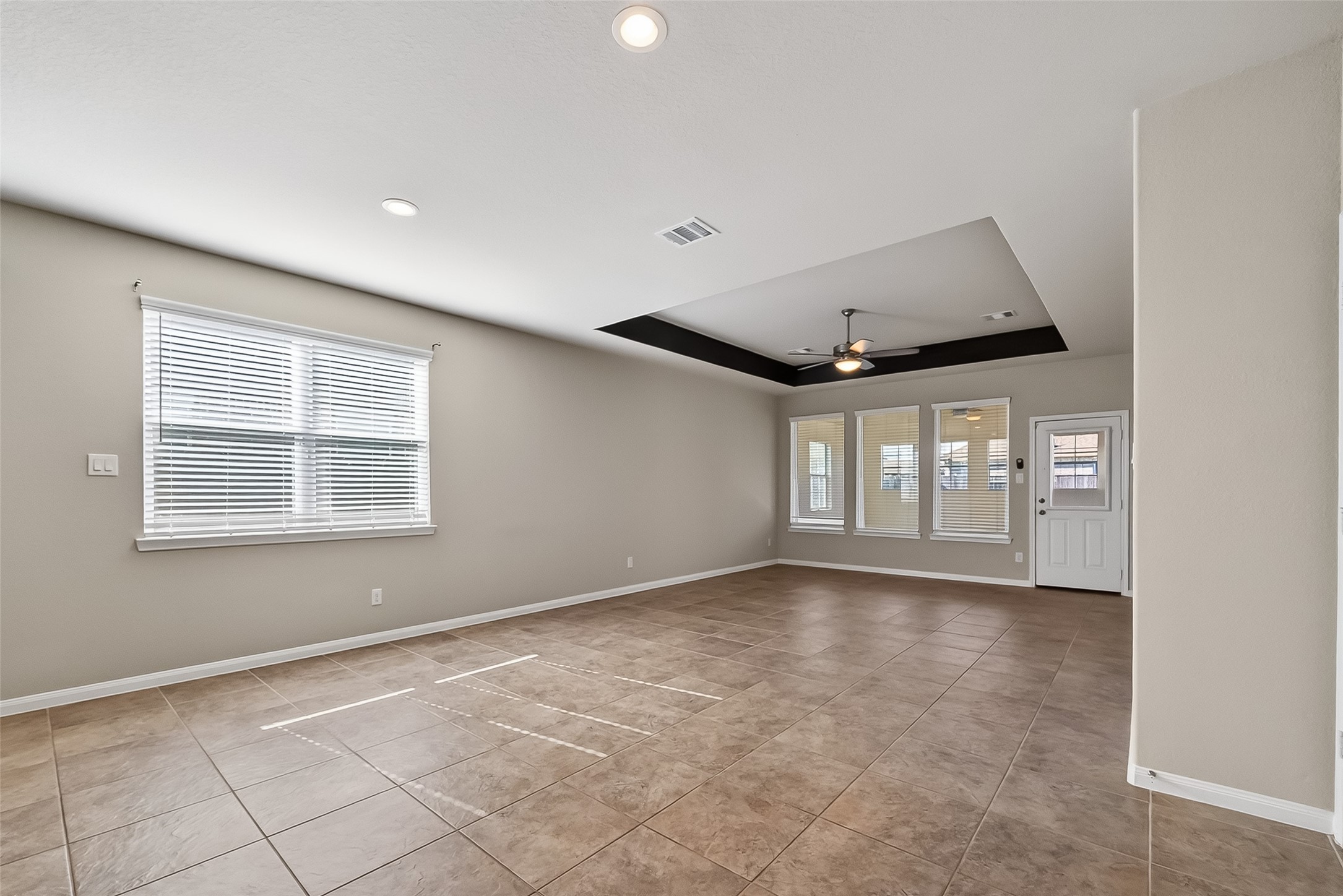 5 Lucas Chase Court Manvel, TX 77578 - Photo 13 of 50 Gather, unwind, repeat — this bright family room features a stylish tray ceiling, wide-set windows for natural light, and a ceiling fan to keep things breezy and comfortable all year long.