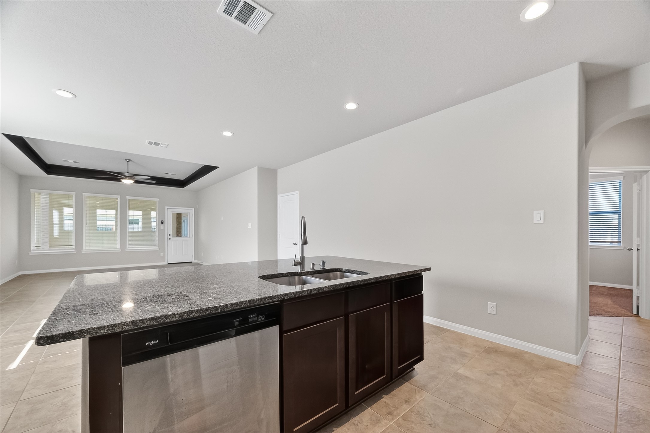 5 Lucas Chase Court Manvel, TX 77578 - Photo 8 of 50 The perfect entertaining hub! This large kitchen island features beautiful granite countertops, a deep sink, and a stainless steel dishwasher, all while overlooking the bright, open living area for seamless socializing.