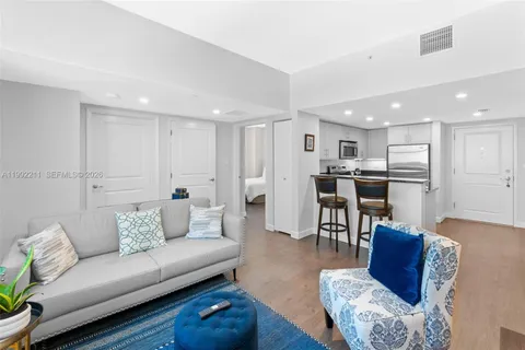 a living room with furniture and a dining table with kitchen view