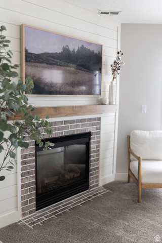 1204 North 3020th Street West Provo, UT 84601 - Photo 18 of 35 Corner fireplace with brick and shiplap surround and a wood mantel