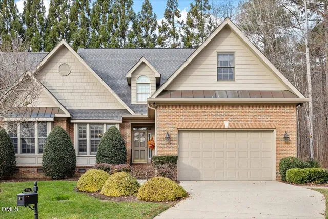 a view of a white house with a yard and plants