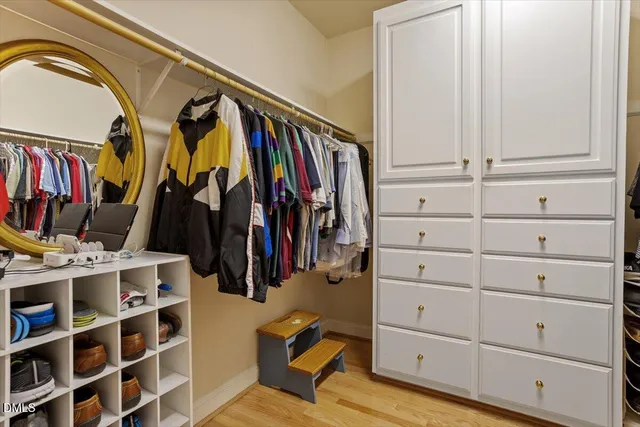 a view of walk in closet with clothes and shoes