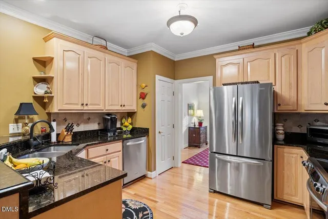 a kitchen with granite countertop stainless steel appliances a refrigerator a stove top oven and cabinets