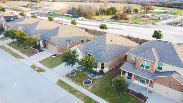 an aerial view of residential houses with outdoor space and parking