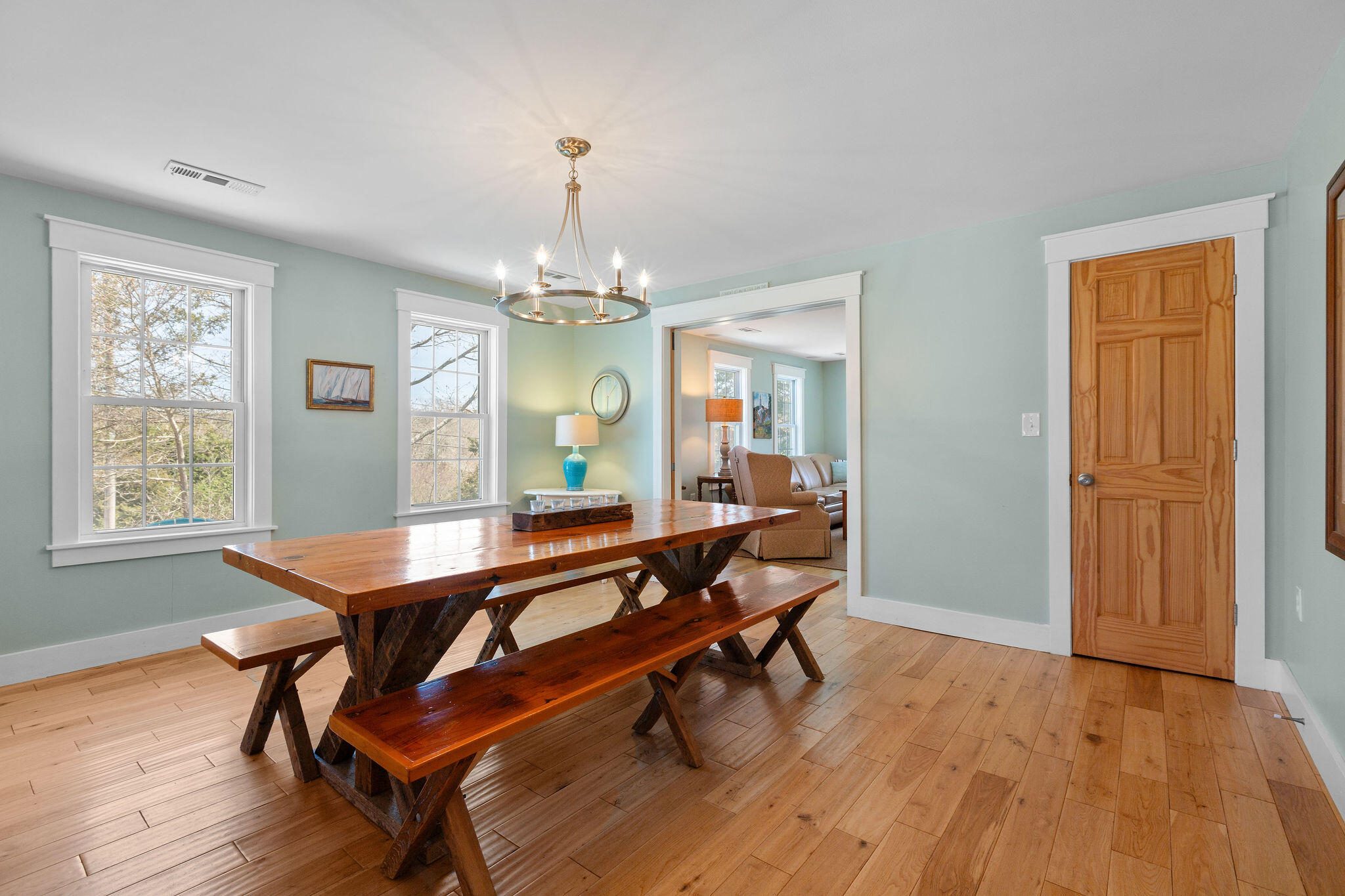 16 Hughes Road Truro, MA 02666 - Photo 18 of 50 a dining room with wooden floor a chandelier a wooden table and chairs