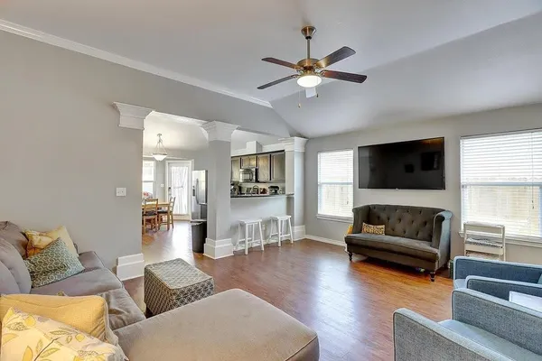 a living room with furniture a ceiling fan a fireplace and a window