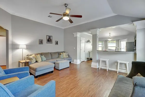 a living room with furniture and a wooden floor
