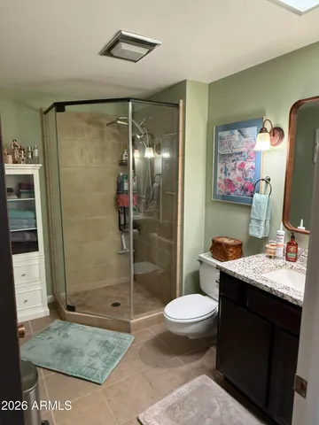 a bathroom with a granite countertop sink toilet and shower