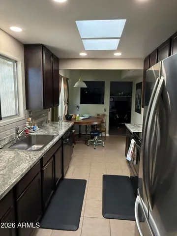 a kitchen with stainless steel appliances granite countertop a sink refrigerator and cabinets