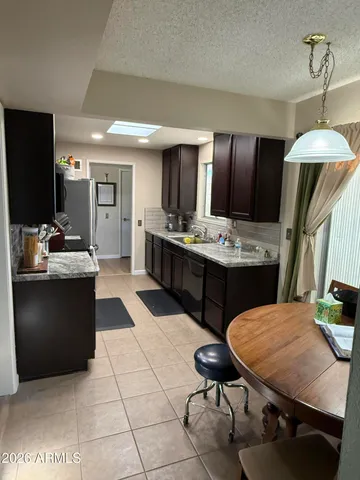 a kitchen with a table chairs and a refrigerator