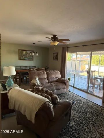 a living room with furniture a large window and a rug
