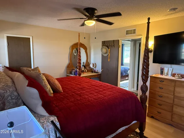 a bed room with a bed a television and a dresser