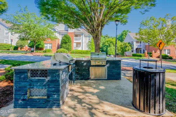 a view of a patio with table and chairs and a barbeque