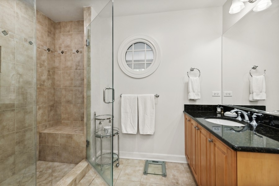 1918 Lynn Circle Libertyville, IL 60048 - Photo 9 of 17 a bathroom with a granite countertop shower a sink and a mirror