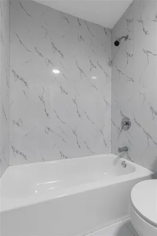 a bathroom with a bathtub and a toilet