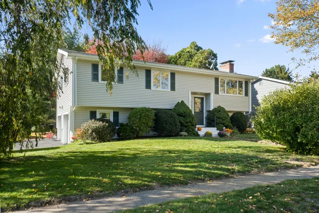 a front view of a house with a yard and potted plants