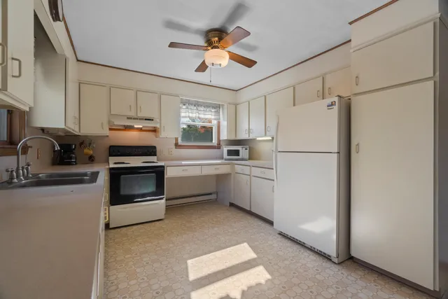 a kitchen with cabinets stainless steel appliances and a window
